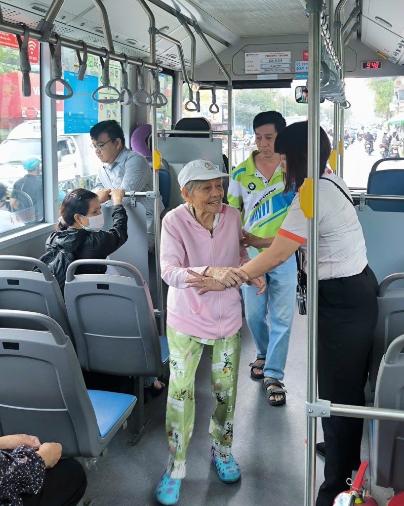 Bus staff carefully guide older passengers to their seats