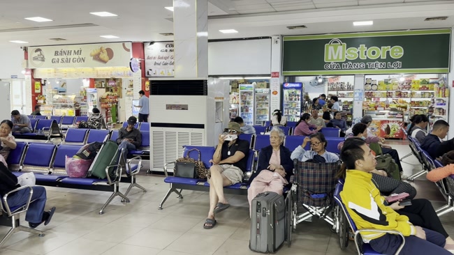 Hành khách ngồi chờ trong sảnh nhà ga